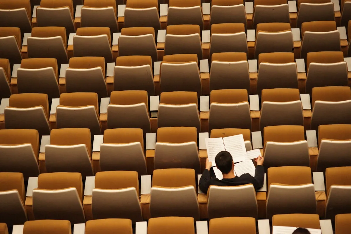 A student reading in a lecture hall